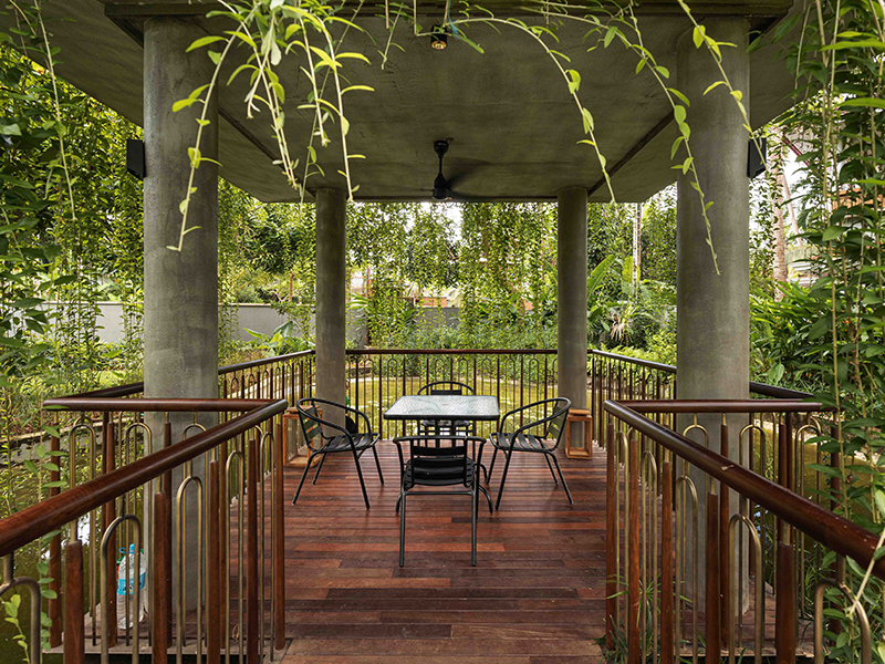 Lush greenery and a koi water body surround the intimate outdoor hosting space at the Zen Den. (Image Credits: Turtle Arts)