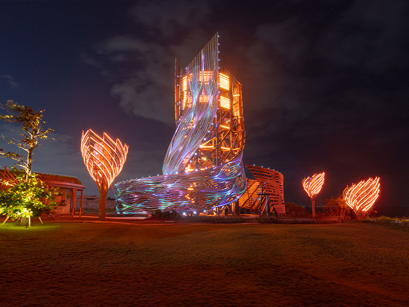Rising 24 meters high at the edge of Nuanu, the THK Tower—designed by French architect Arthur Mamou-Mani—serves as a striking landmark by day and a luminous digital canvas by night. The tower comes alive with a 360-degree generative art and light show at nightfall. (Image Credit: Nuano Creative City)