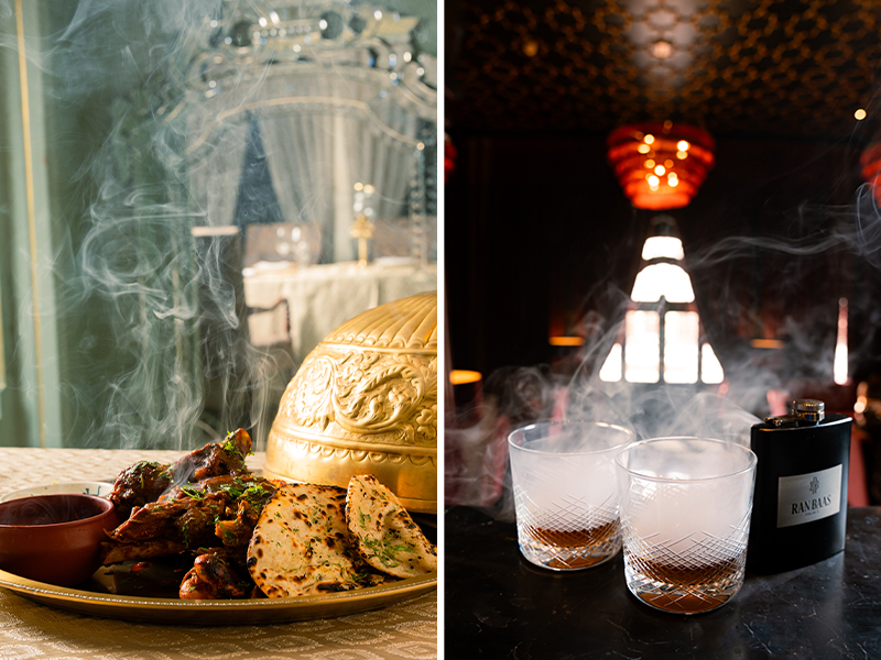 The Kandahari Raan, a smoky, coal-scented shared feast for two, arrives ‘Dhungar-style’. A perfect pre-dinner drink to this dish is the ‘Scandal Point’—a heady Patiala-style medley of spirits is served in a custom Ran Baas flask. (Image Credit: Ran Baas- The Palace Hotel)