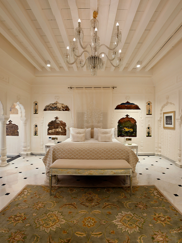 The all-white ‘Shikargarh Suite’ shimmers with quiet opulence, featuring a custom-carved marble bed, Venetian glass mirrors, crystal-cut furniture, and drapes woven with silver and gold accents. (Image credit: Ran Baas- The Palace Hotel)