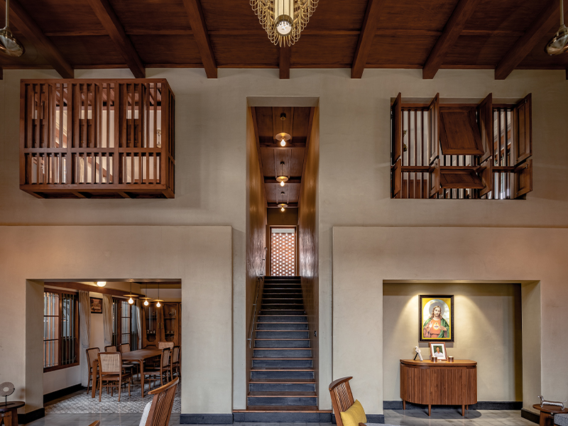 The central stairs and wooden shutters create a harmonious play on volumes, guiding you deeper into the home. (Image Credits: Roy Antony Architects)