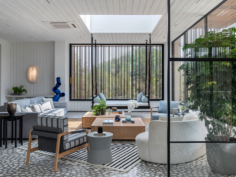 The living room on the top floor features a skylight to complement the lighting fixtures and illuminate the bright blue totem, all by Ashiesh Shah. The furniture is from Josmo Studio. (Image Credits: PHX India)