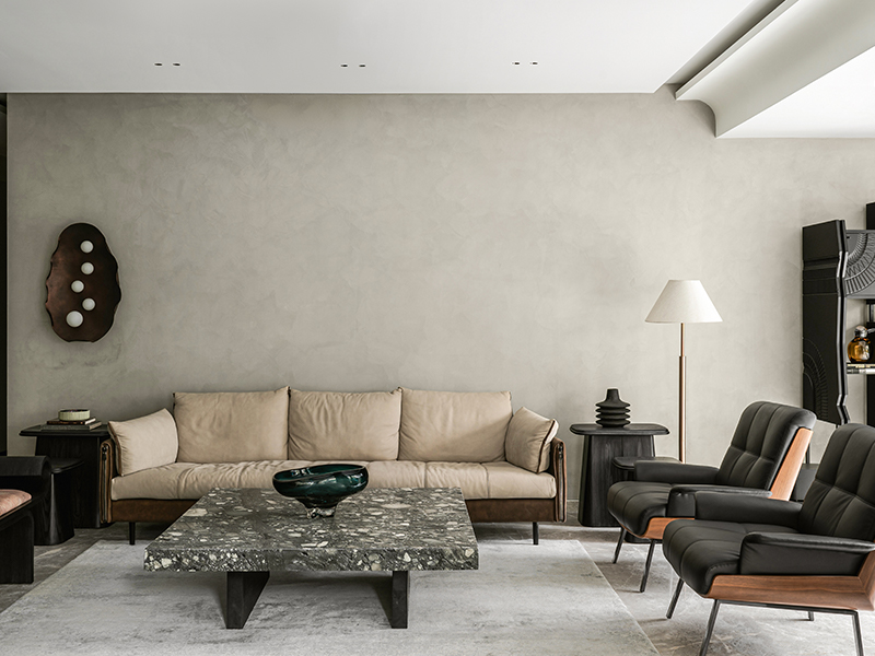A Shailesh Rajput Studio light inspired by an oyster shell softens the clean architectural lines of the living room with its cool-grey basalt-clad column. (Image Credits: Tarang Goyal)