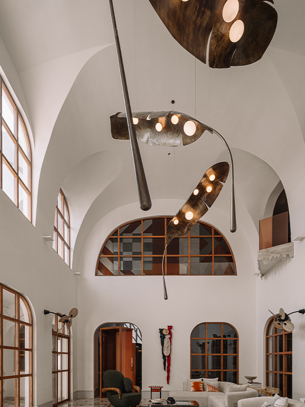 A floating leaf luminaire by Shailesh Rajput adds a contemporary Indian touch to the double-height living space. (Image Credits: Ishita Sitwala)