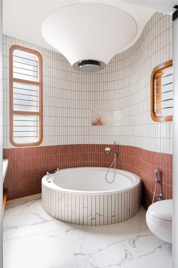 The House of Curve, designed by Terra Firma, the daughter’s bathroom is instantly elevated with the striking tensile shower light from Futura Lighting, sleek bathroom fittings by Grohe, and fixtures by Villeroy & Boch–the focal point of the space, which presents a clean and cohesive design. (Image Credit: MKG Studios)