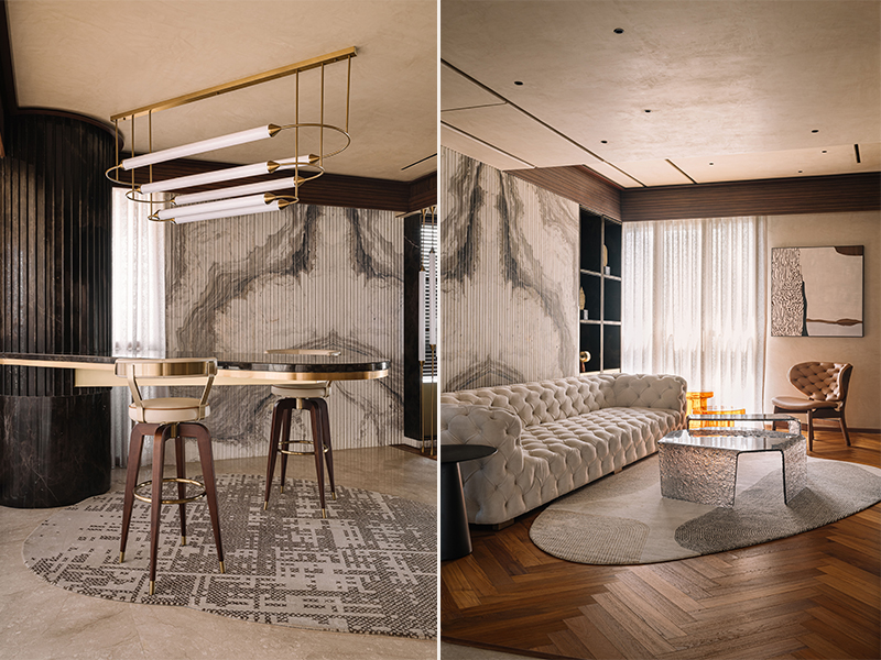 Left: The hosting alcove houses a bespoke stone counter attached to the column, along with bar chairs, and a pendant lighting from Poshway, becoming an extended hangout spot. Right: The lounge with a Chesterfield couch and frosted glass coffee tables from Poshway, overlooking the wooden herringbone flooring covered with a rug from Atelier Textile Epic, is perfect for movie nights. (Image Credits: Ishita Sitwala)