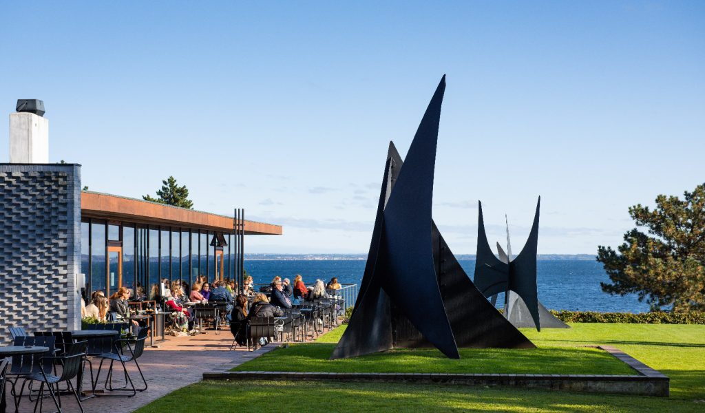 The Louisiana Café offers both elegant indoor dining framed by glass walls and alfresco seating on the terrace, paired with sweeping views of Alexander Calder’s majestic sculptures on the iconic Calder Terrace. (Image Credit: Kim Hansen)