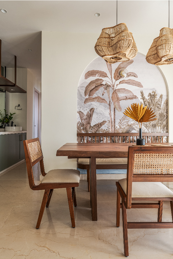 The richly grained dining table, side bench and chairs are made on-site. The bamboo light fixtures are from Luuma lights. The botanical wallpaper was picked from Metamorph.
(Image Credits: Aditya Warlikar)
