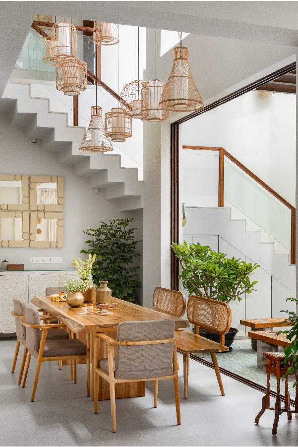The dining table is custom-made by Meraki Arts. The papier mache wall mirrors in earthy tones, handpicked from small Indian artisans, add personality and rhythm without cluttering the space. The terrazzo flooring in soft beige tones lends a warm but neutral base and complements the textural layers above. (Image Credits: Aaditya Kulkarni)