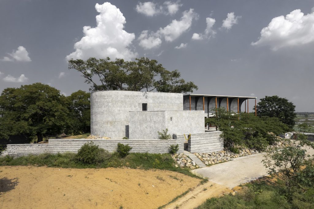 The austere granite façade, carved by local craftsmen, echoes temple typologies and embodies the site’s rugged, sacred terrain. (Image Credits: Niveditaa Gupta)
