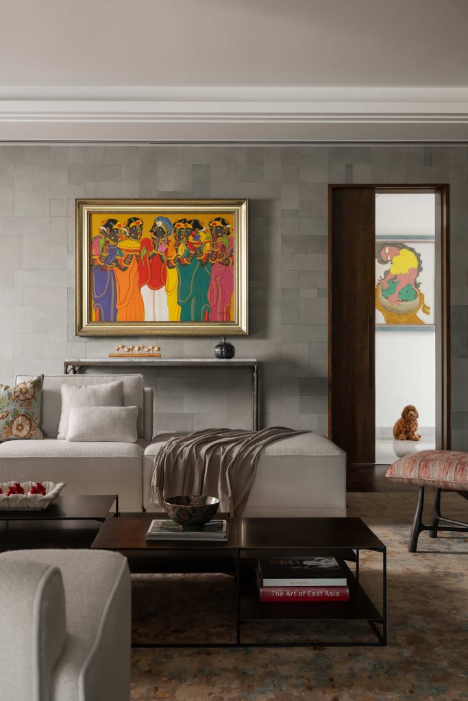 In the family lounge, beige textured sofas from Casa Walls are paired with art by Thota Vaikuntham and a piece by Prokash Parmar near the powder room, while a K2 ottoman completes the ensemble. (Image Credits: Arjun Kirshna)
