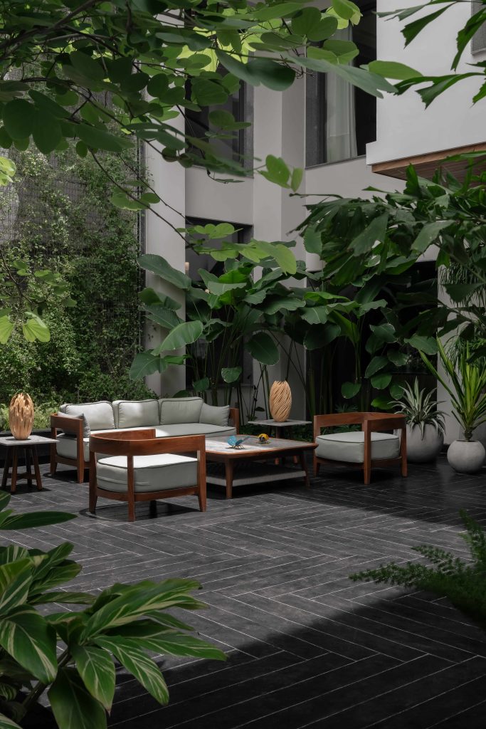 In the 18,000 sq. ft. Hyderabad home, Balinese warmth unfolds through teakwood sofas from The Garden Room, and a wooden vase from Thailand. (Image Credits: Arjun Kirshna)