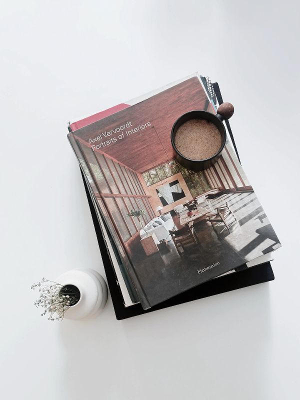 The book “Portraits of Interiors” rests elegantly on a white table, its muted cover echoing the serene, earthy interiors within. (Image Credits: Design Pataki)