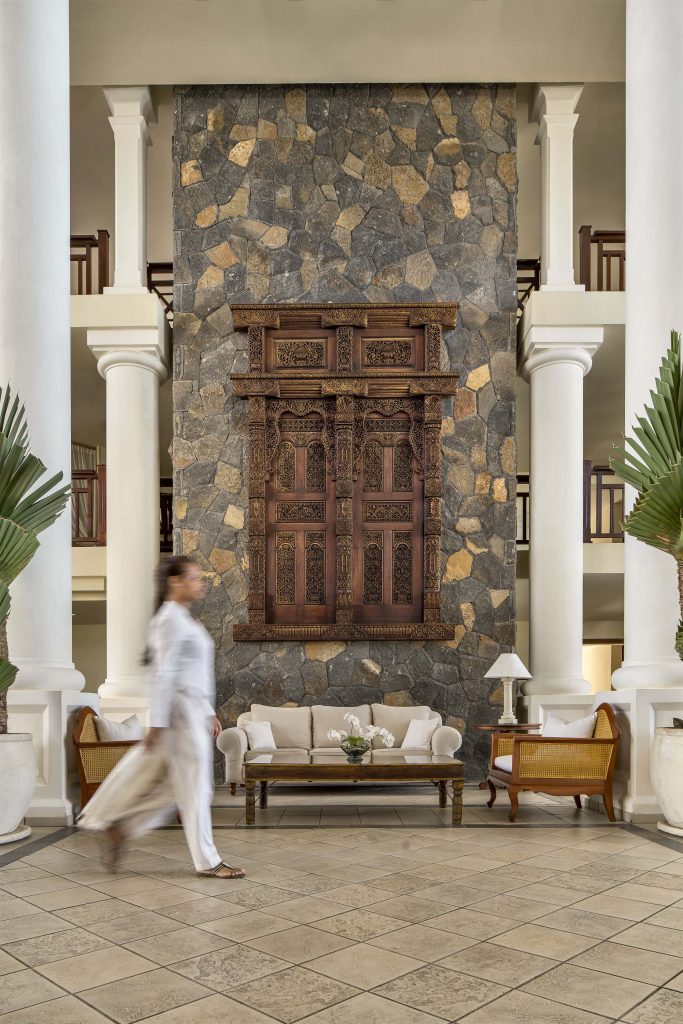 The entrance lobby sets the stage for a grand arrival, defined by intricate timber craftsmanship and stately columns.  (Image Credit: Residence Mauritius)
