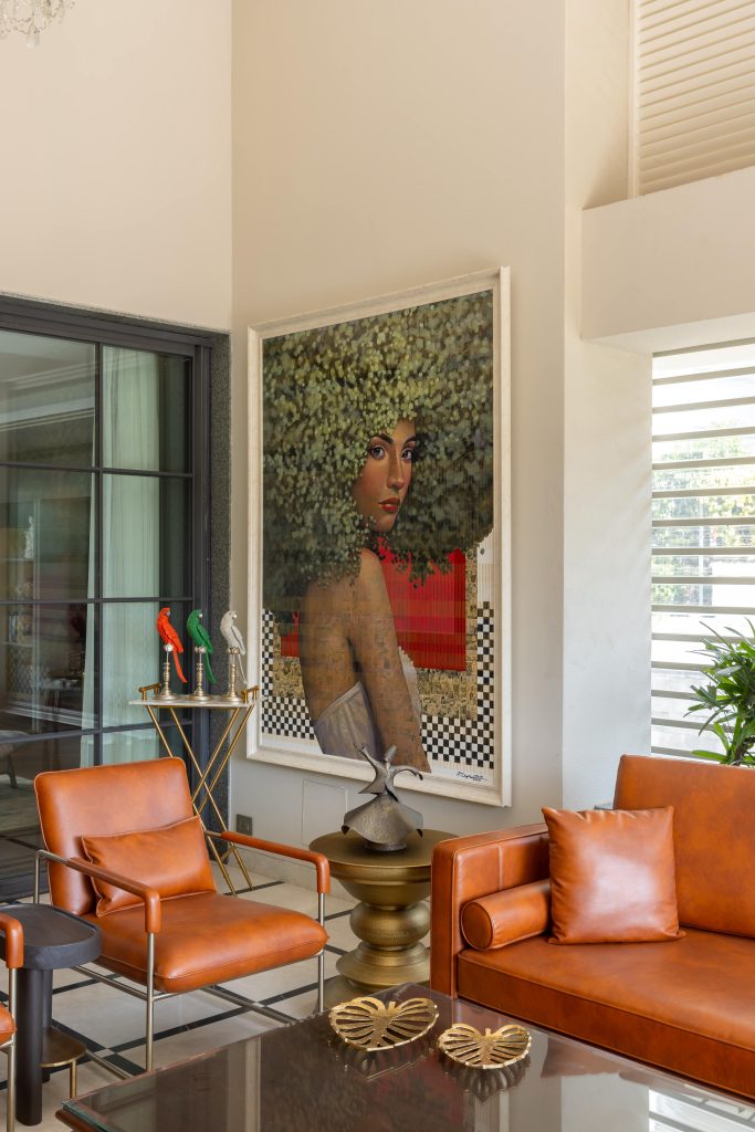 The pièce de résistance of the room is a Thai painting titled ‘The Green-Haired Girl,’ which is framed by a rust Cassawalls sofa and a Jaipur brass side table from Anantaya. (Image Credits: Ravi Varma) 