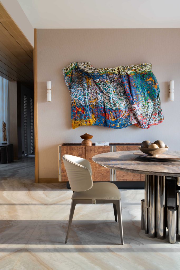 Left: The dining zone is enlivened by a papier-mâché artwork by artist Smita Kinkale. A lush-veined credenza completes the setting. 
