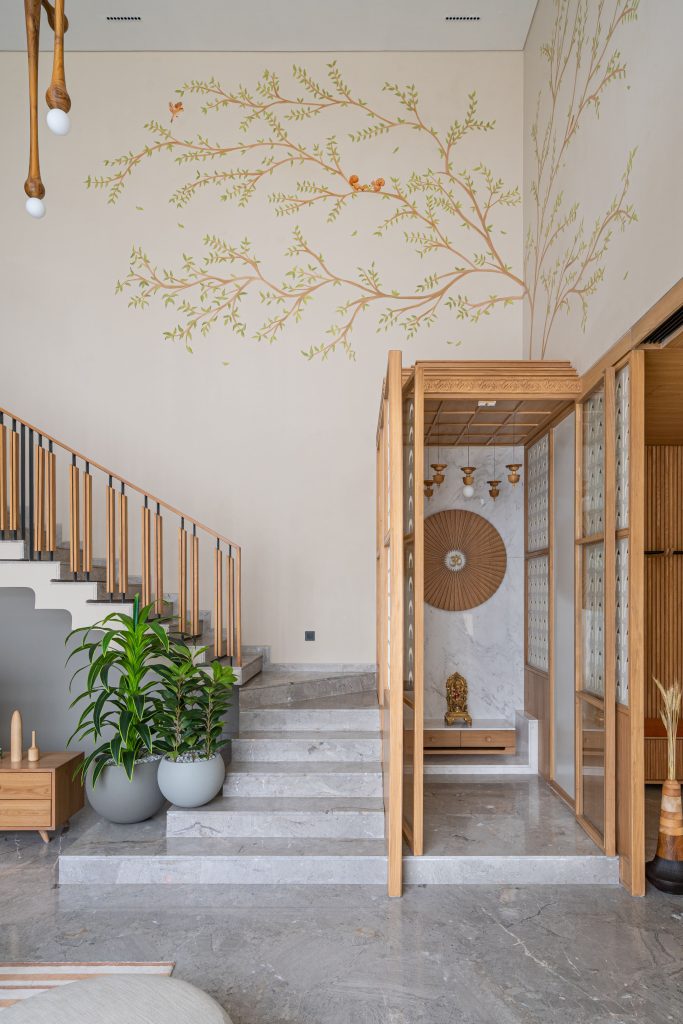 Rooted in a minimalist aesthetic, this mandir is a beautiful convergence of contemporary design and timeless spiritual essence. The tree mural is made by Paneri Art Studio. (Image Credits: Chetan Jain) 