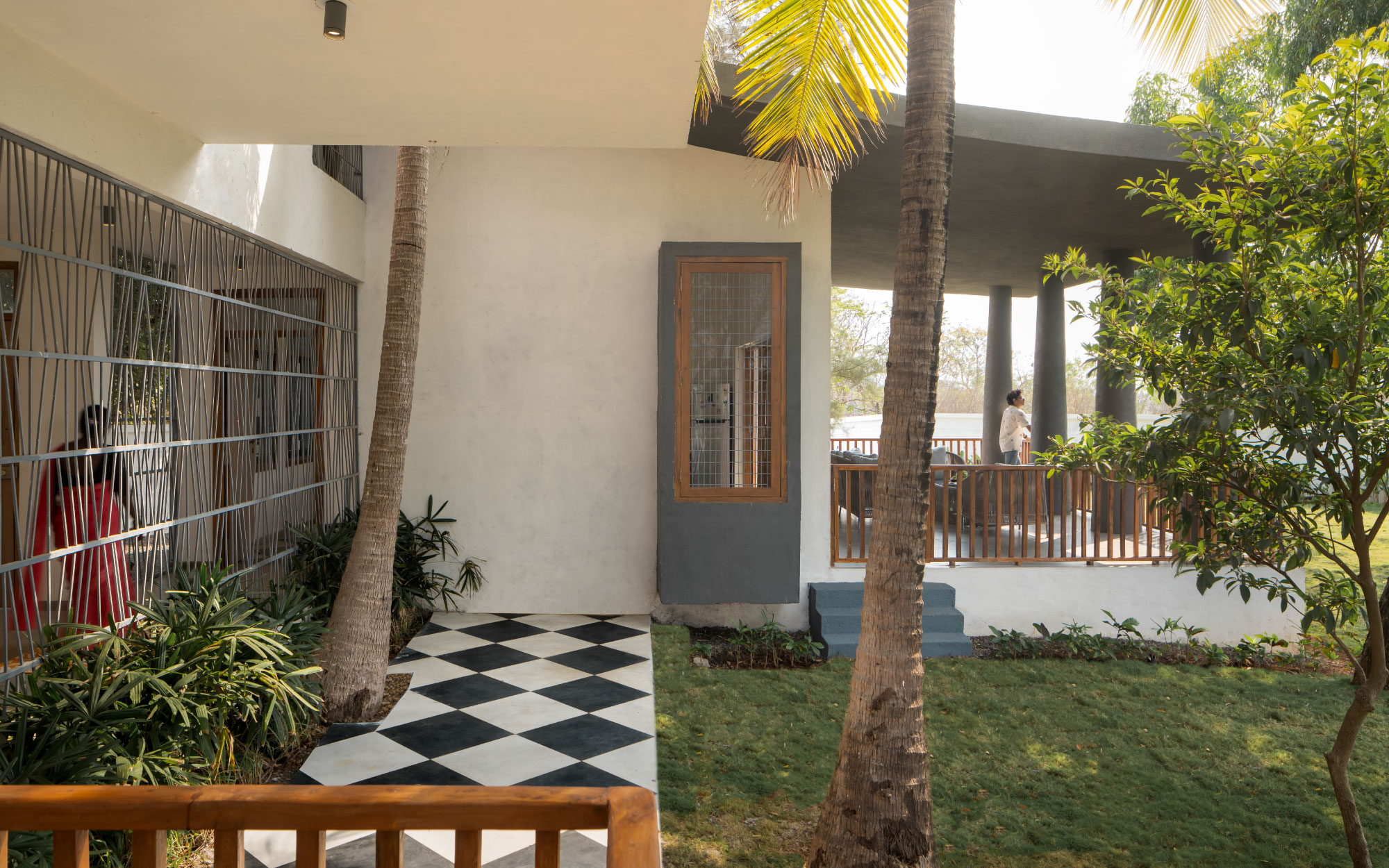 The breezeway linking the two blocks is adorned with Harlequin flooring by Nitco Tiles, while the home’s pristine and charcoal hues are curated from Asian Paints. (Image Credits: Ekansh Goel)