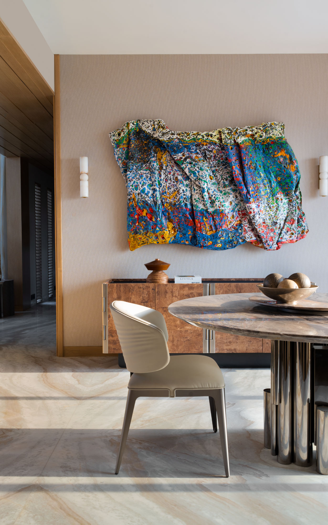 Left: The dining zone is enlivened by a papier-mâché artwork by artist Smita Kinkale. A lush-veined credenza completes the setting.
