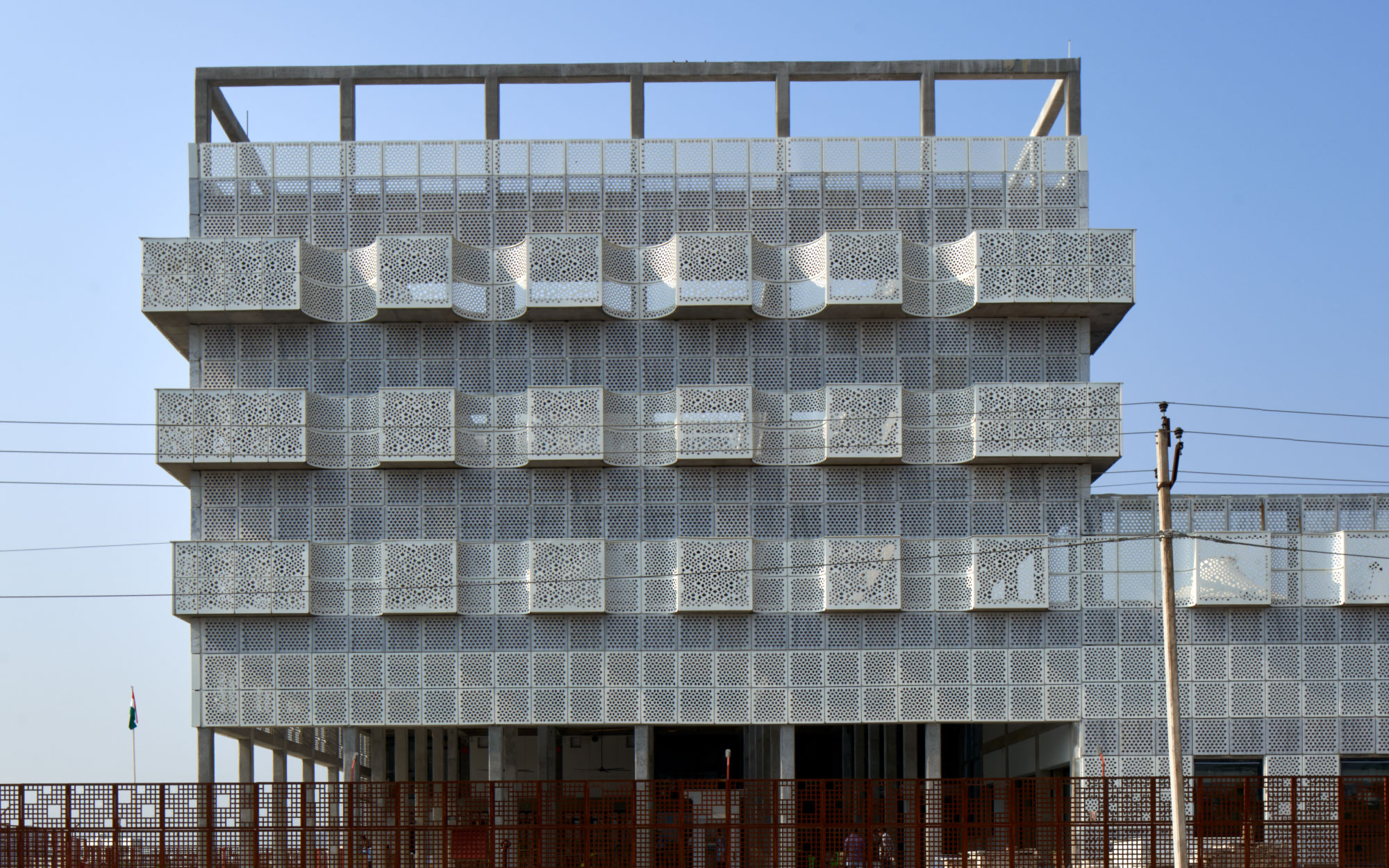 The façade, with its cantilevered gokhras and intricate jali screens, fuses climatic responsiveness with cultural resonance. (Image Credits: Edmund Sumner)