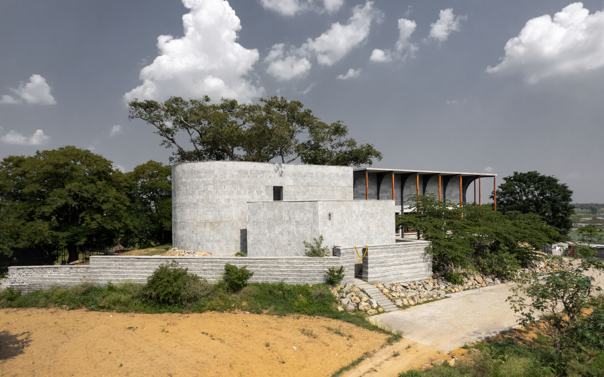 The austere granite façade, carved by local craftsmen, echoes temple typologies and embodies the site’s rugged, sacred terrain. (Image Credits: Niveditaa Gupta)