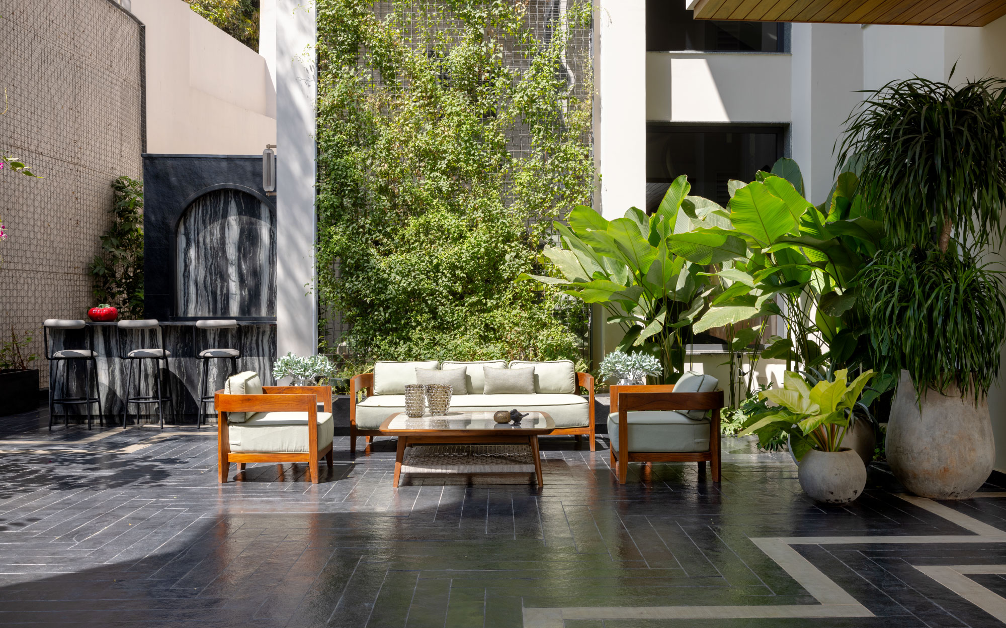 In the 18,000 sq. ft. Hyderabad home, Balinese warmth unfolds through teakwood sofas from The Garden Room, and a wooden vase from Thailand. (Image Credits: Ravi Varma)