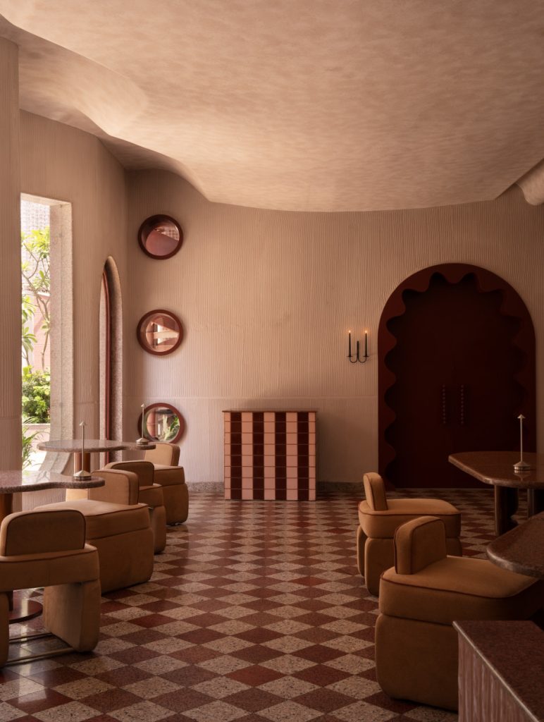 The main dining area unfolds in soft curves, arches and sculpted ceiling, where custom seating, textured plaster walls and sculptural tables converge to create an inviting, minimal setting. (Image Credits: Avesh Gaur)