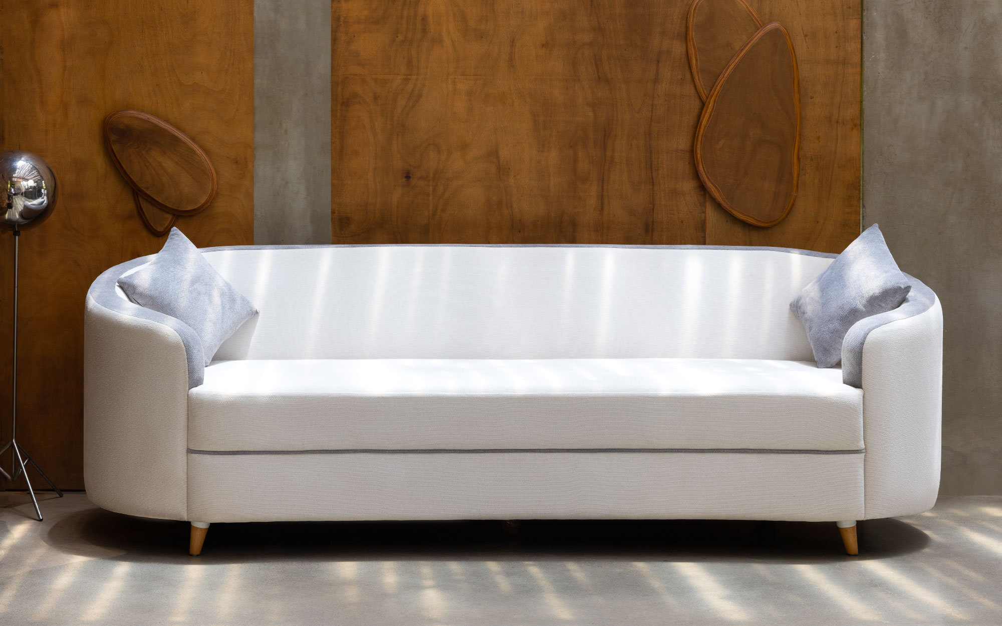 Crafted with precision, this sofa boasts elegant arches and slanted wood legs, exuding sophistication in every curve. (Image Credits: Lagom)