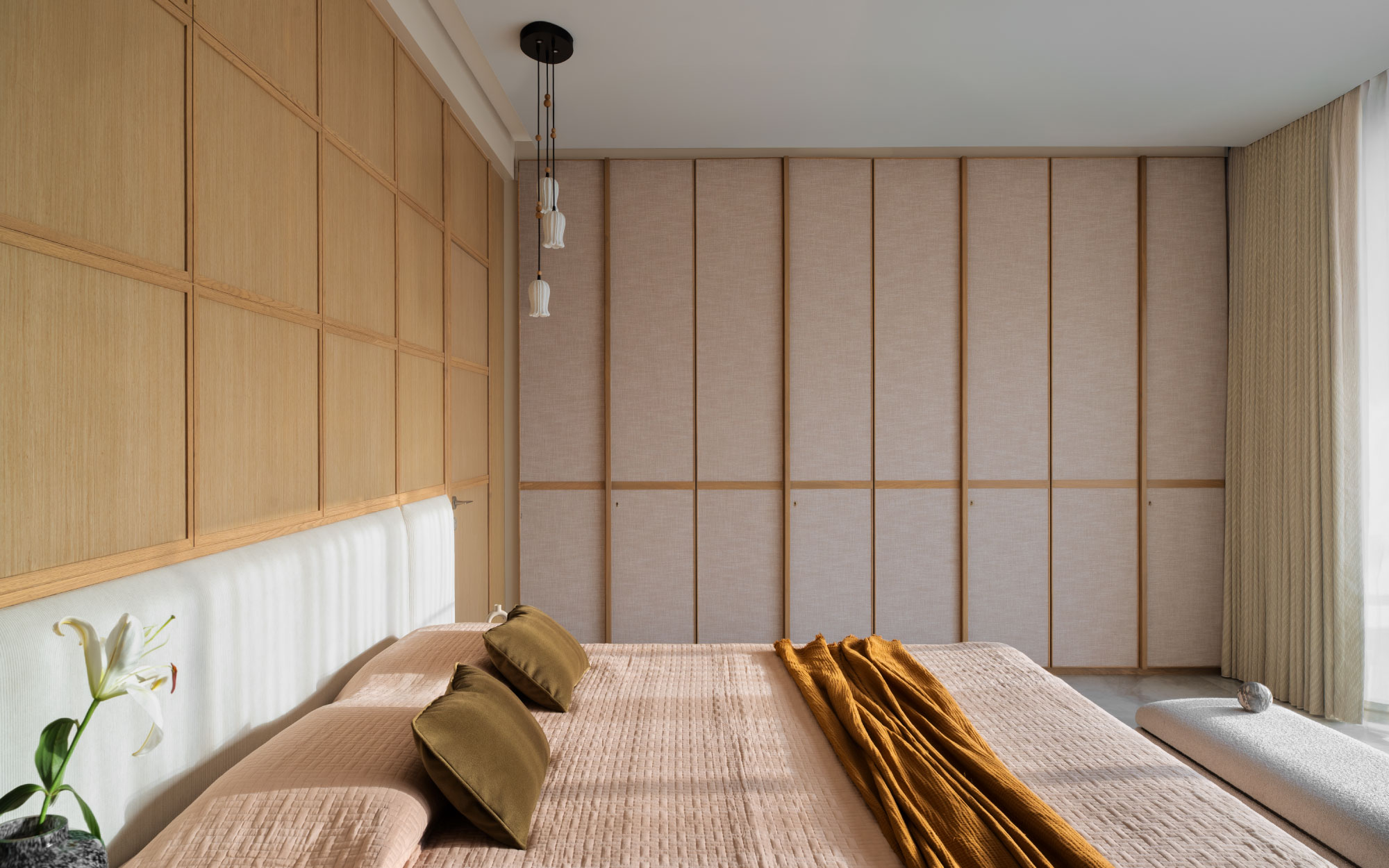 Awash in natural light, the master suite illustrates the power of simplicity done right. The lotus pendant lamps are sourced from Saijal Goenka. (Image Credits: Rohit Mendiratta)