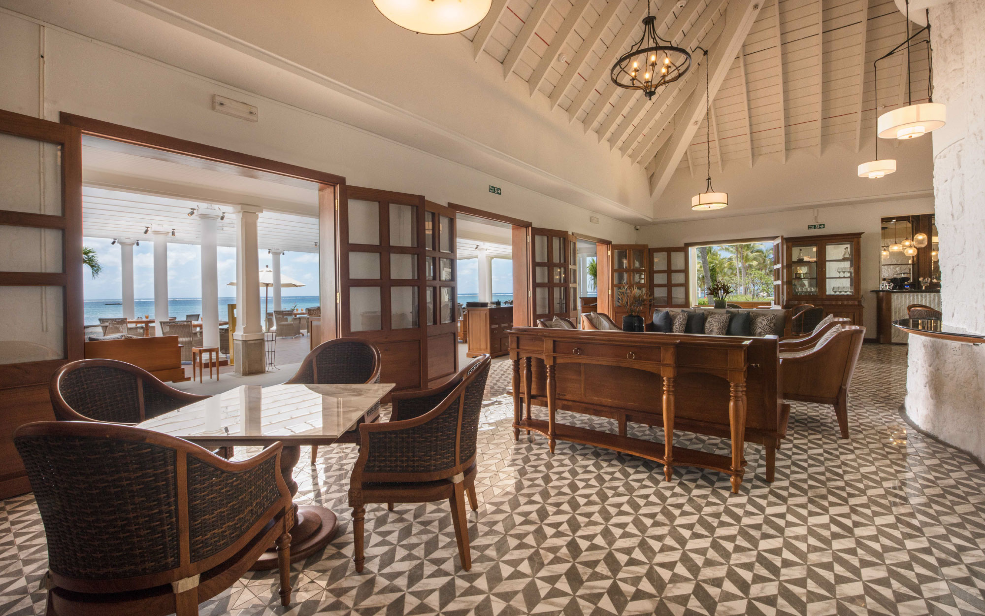 The Plantation dining space blends colonial elegance with a breezy indoor–outdoor layout, framed by stately columns and shaded beneath charming trellised roofs. (Image Credit: Residence Mauritius)