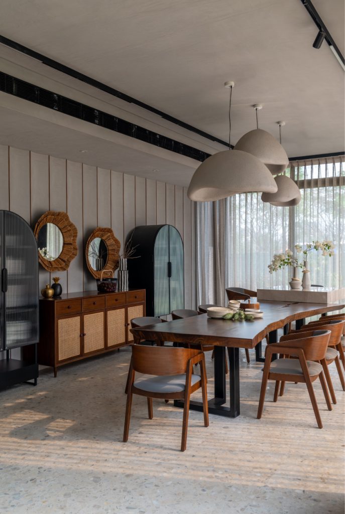 Stone-textured sculptural pendant lights in the dining area are conceptualised and crafted by Blinkbox for A&K Design Studio. (Image Credits: Kuber Shah)