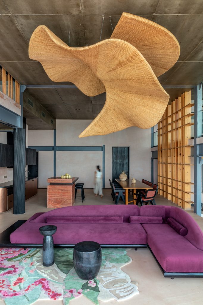 A sculptural luminaire made of natural cane and Assamese rattan, becomes a quiet focal point in the double-height lounge, timeless in its presence and deeply rooted in the craft that shaped it. (Image Credits: Pankaj Anand)