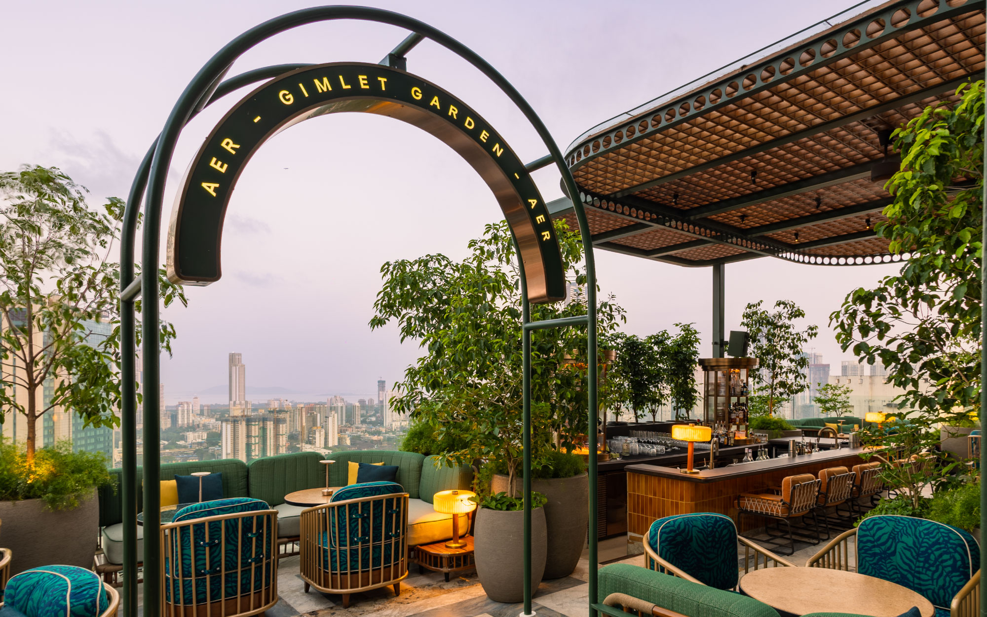 AER rooftop bar offers a chic, open-air escape with nautical-inspired interiors and two distinct zones, the sea-facing Yacht Club and the intimate Gimlet Garden, set against the Mumbai skyline. (Image Credit: Four Seasons Mumbai)