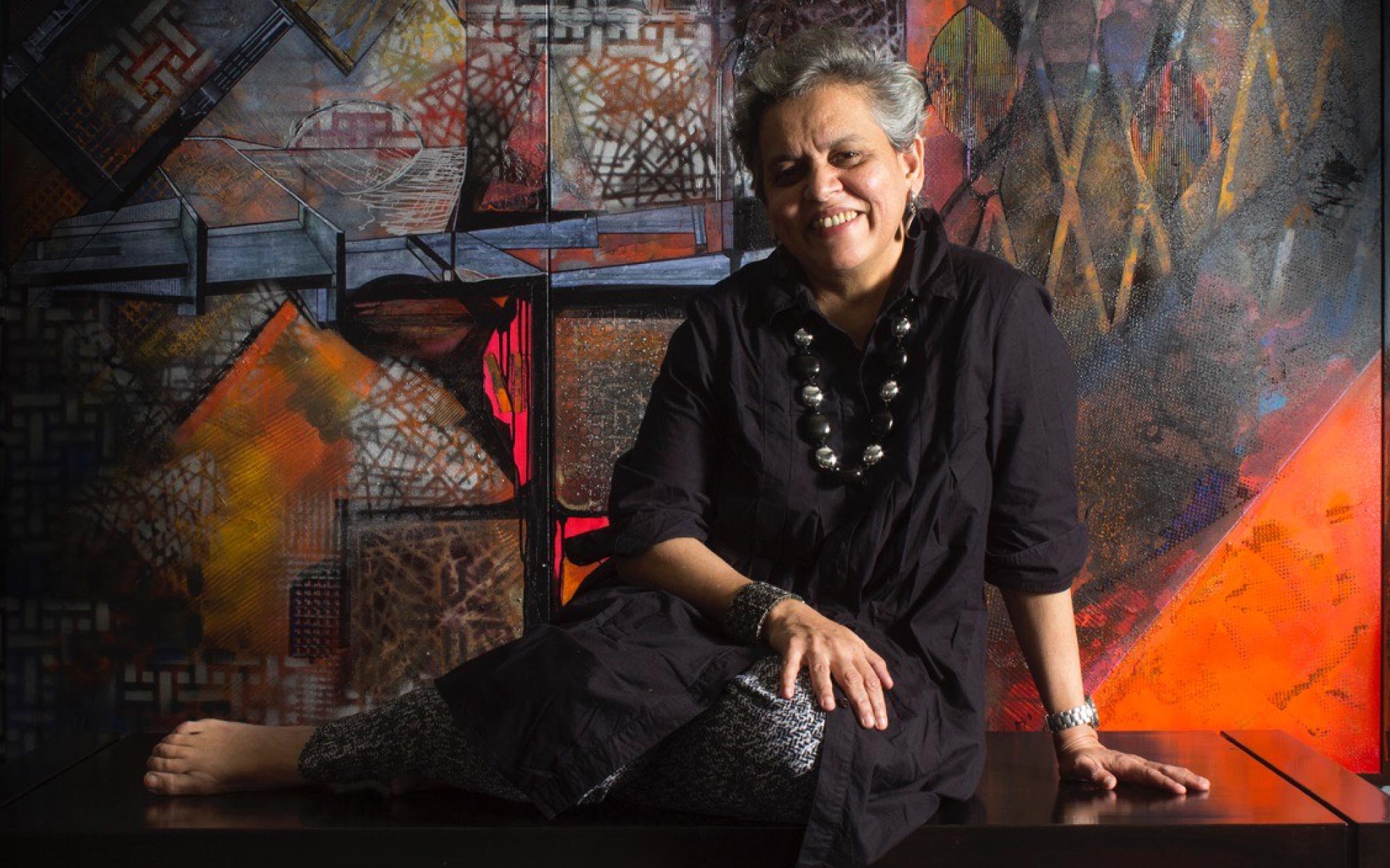 Brinda Miller is pictured amidst her artworks, reflecting a practice shaped by material depth and urban sensibility. (Image Credits: Shiresh Karrale)