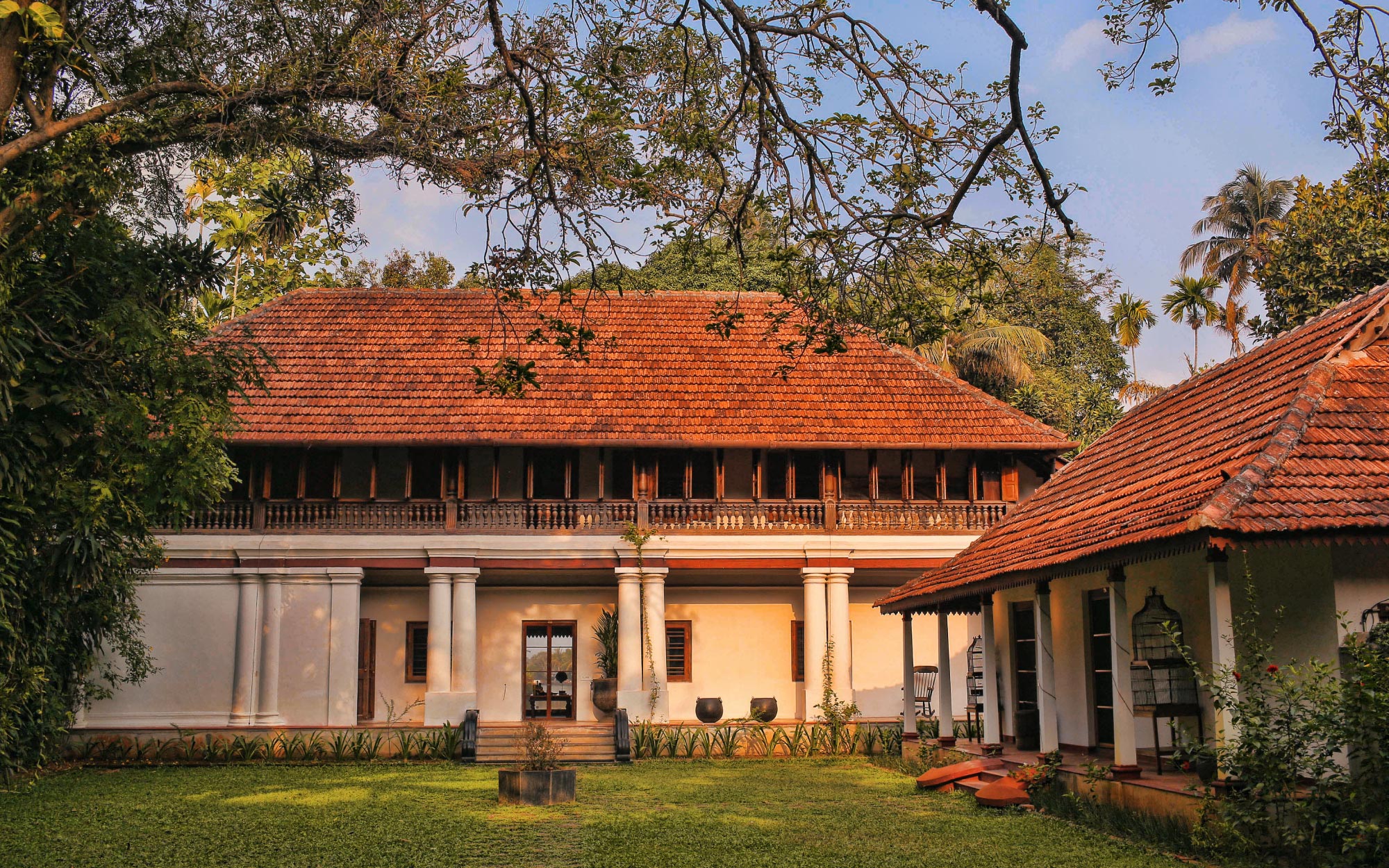 Chittoor Kottaram, a CGH Earth Experience, with its red-tiled roofs and rolling lawn, opens out to a tranquil lagoon. (Image Credits: CGH Earth)