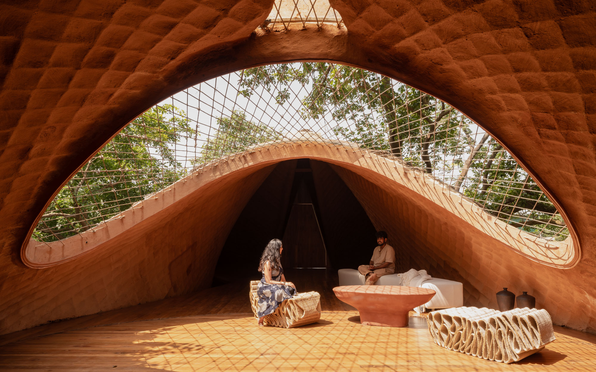 The oculus draws daylight deep into the living area, puncturing its darker core and gently illuminating the space from above. (Image Credits: Studio IKSHA)