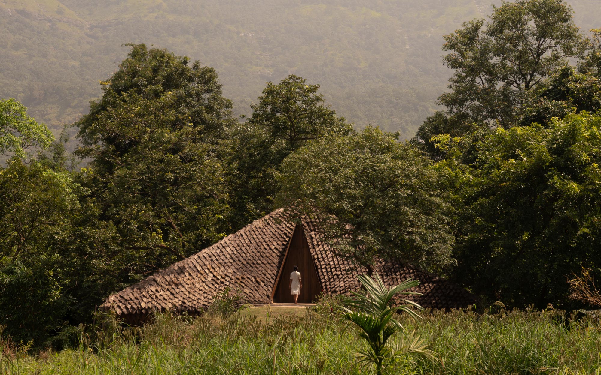 The triangular entry marks a clear threshold between the landscape and the home. (Image Credits: Studio IKSHA)
