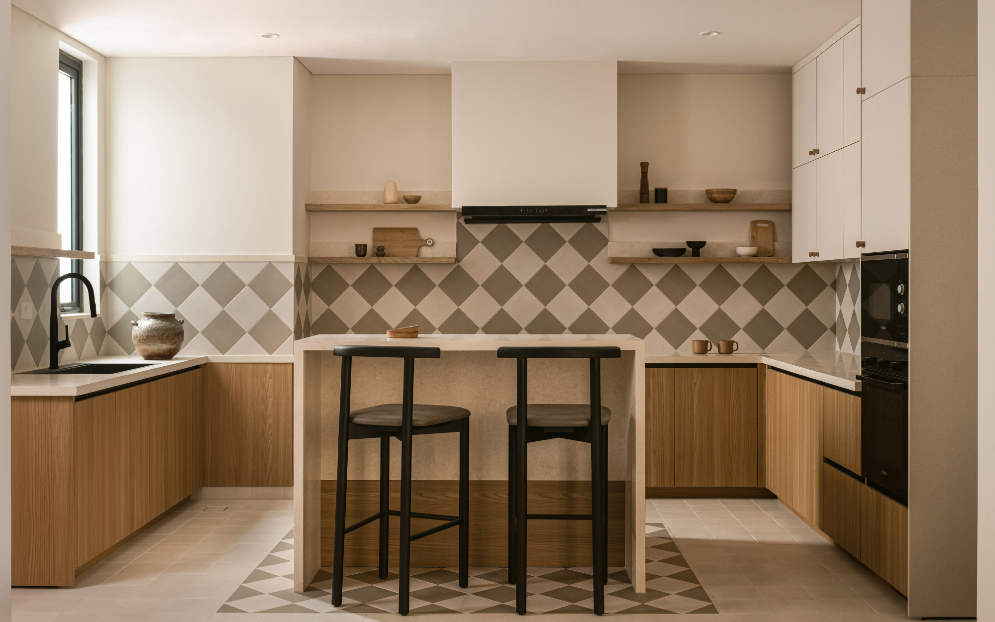 A study in muted contrasts, the kitchen boasts custom-built furniture, wall tiles from Ranze Ceramics, and pristine cabinets from Oaktree. (Image Credits: Nayan Soni)