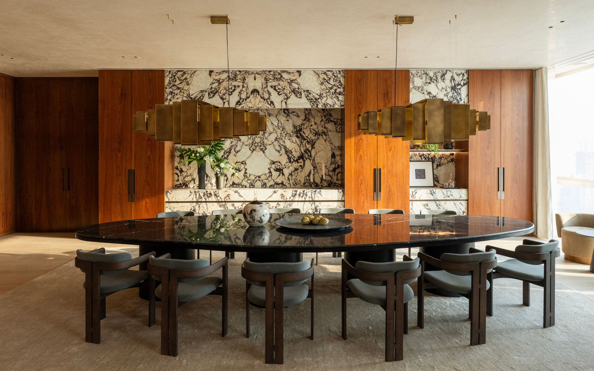 The dining chairs are by Gallotti&Radice, while the dining table and bronze chandeliers are bespoke designs. (Image Credit: Patricia Goijens)