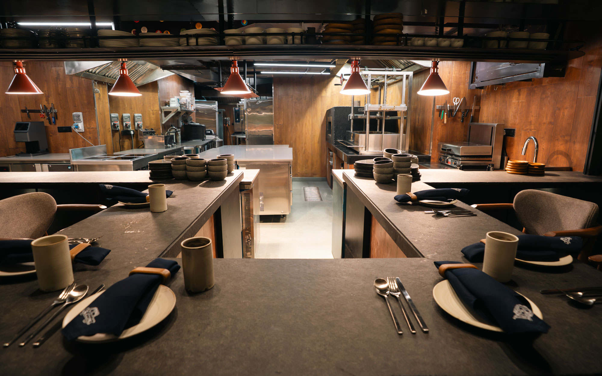 At Hearth, the chef-interactive experience dissolves the kitchen’s fourth wall. Conceived as an enclosed square, the space allows diners to engage with the chefs in an intimate, immersive setting. (Image Credit: Hearth)