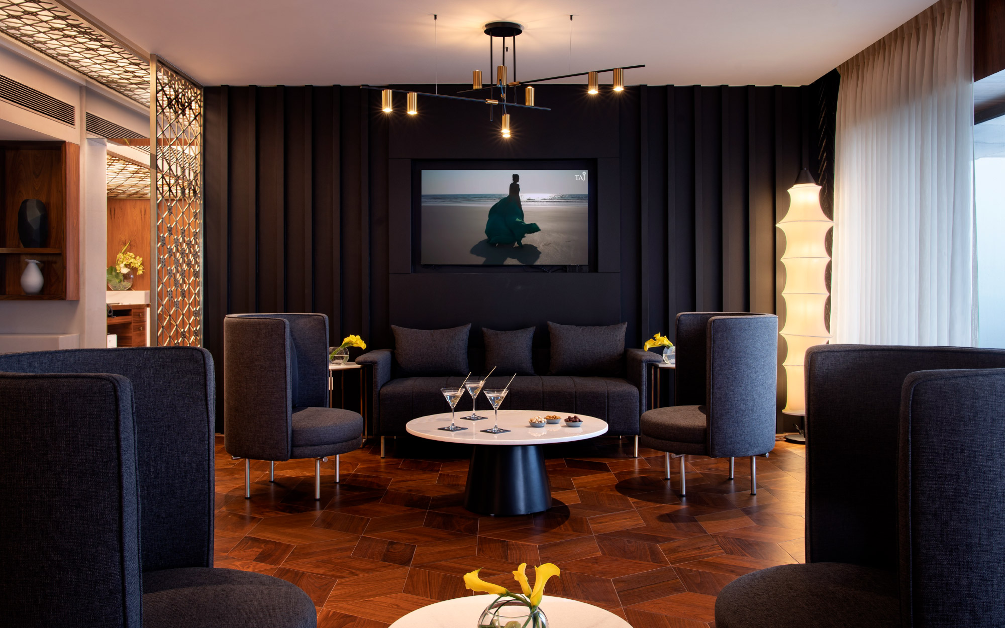 With an airy nautical theme, the Taj Club uses light-colored woods and reflective surfaces to keep the space feeling expansive. (Image Credit: Taj Land’s End)