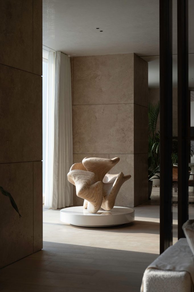 Thanks to wooden claustras, the foyer reveals just enough without holding back on the full reveal. The sculpture is by contemporary artist Harsha Durugadda. (Image Credit: Patricia Goijens)