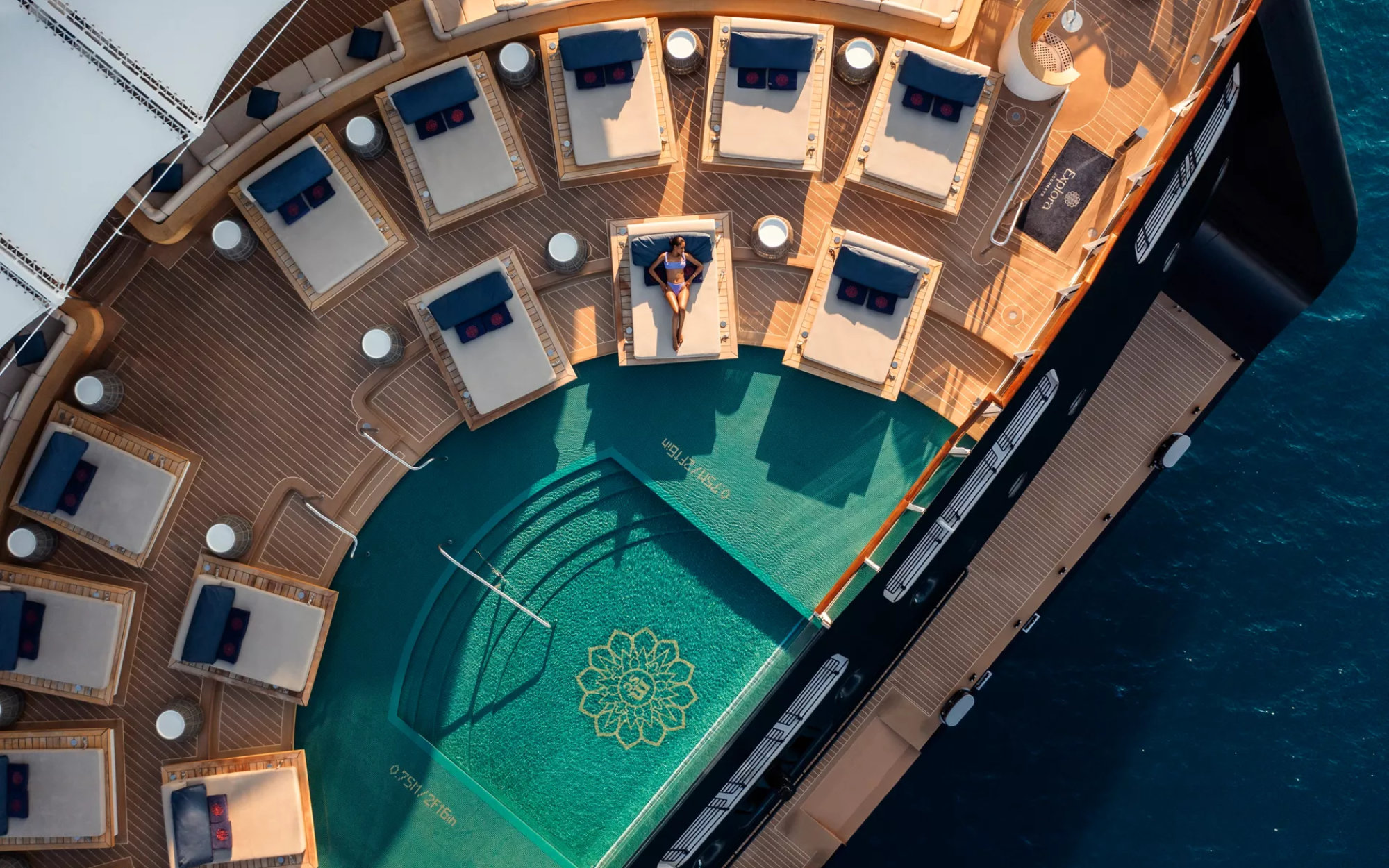 An all-day Astern Lounge sits beside the infinity pool, offering a relaxed waterfront escape with beach-club energy. By day, it hums with low background music; by sunset, acoustic musicians and DJs take over, easing the space into a vibrant evening mood. (Image Credit: Explora Journeys)