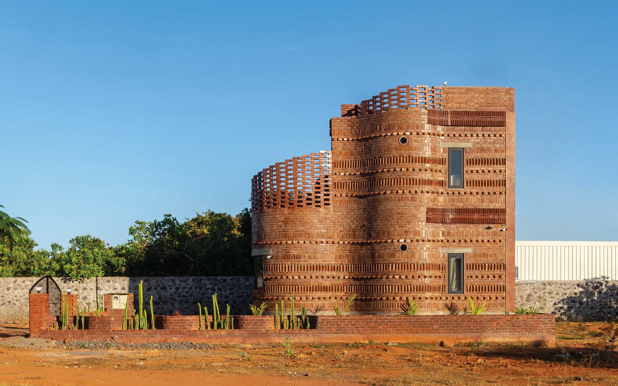 Locally manufactured bricks were chosen for their availability and their earthy palette that mirrors the site and its surrounding landscape. (Image Credits: Kaptured Studios)
