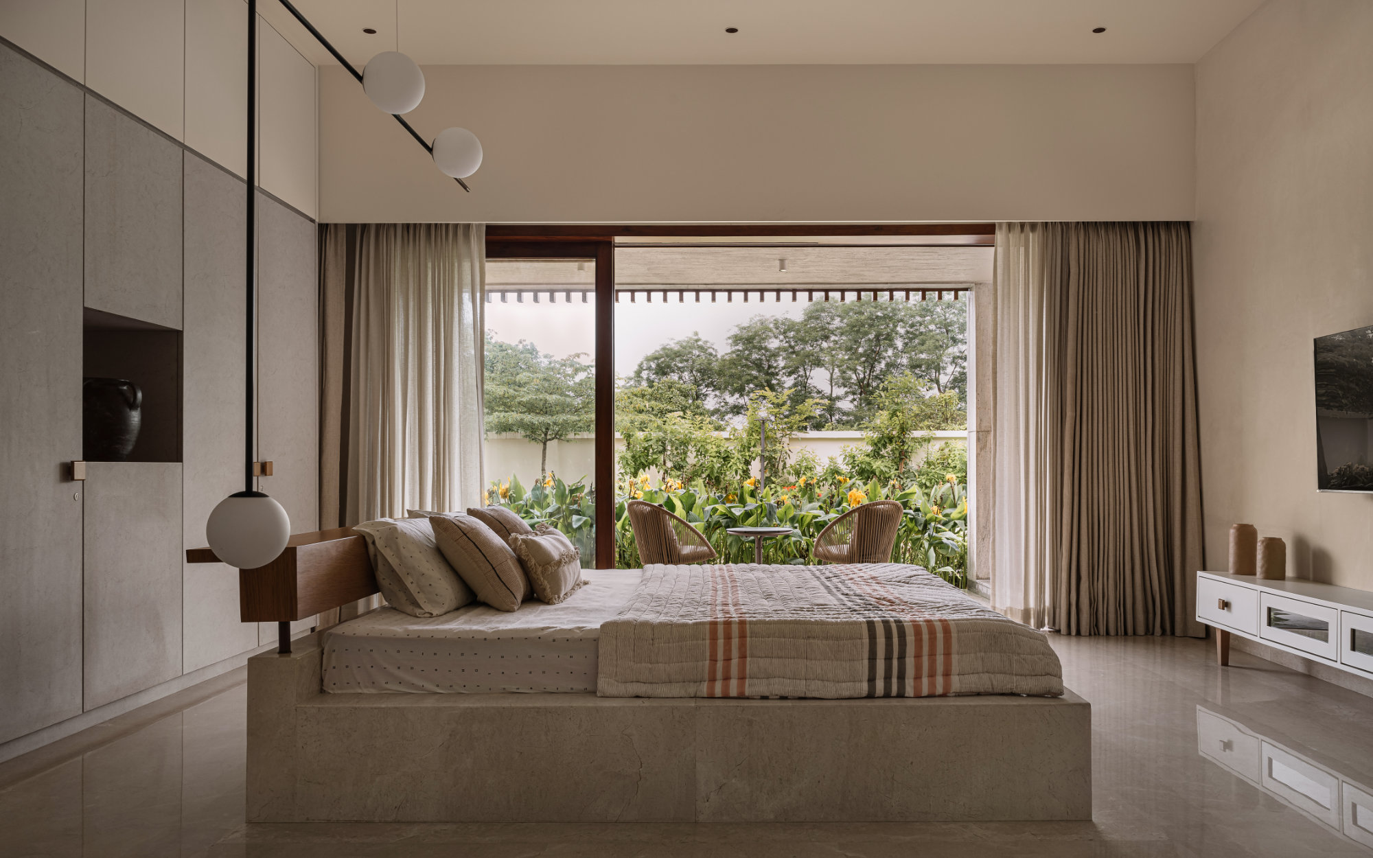 The daughter’s bedroom features a custom-made marble island bed, complemented by a bespoke MS and glass light fitting. Soft furnishings by Abstrac Home complete the space, creating a refined and tactile environment. (Image Credits: Ishita Sitwala)
