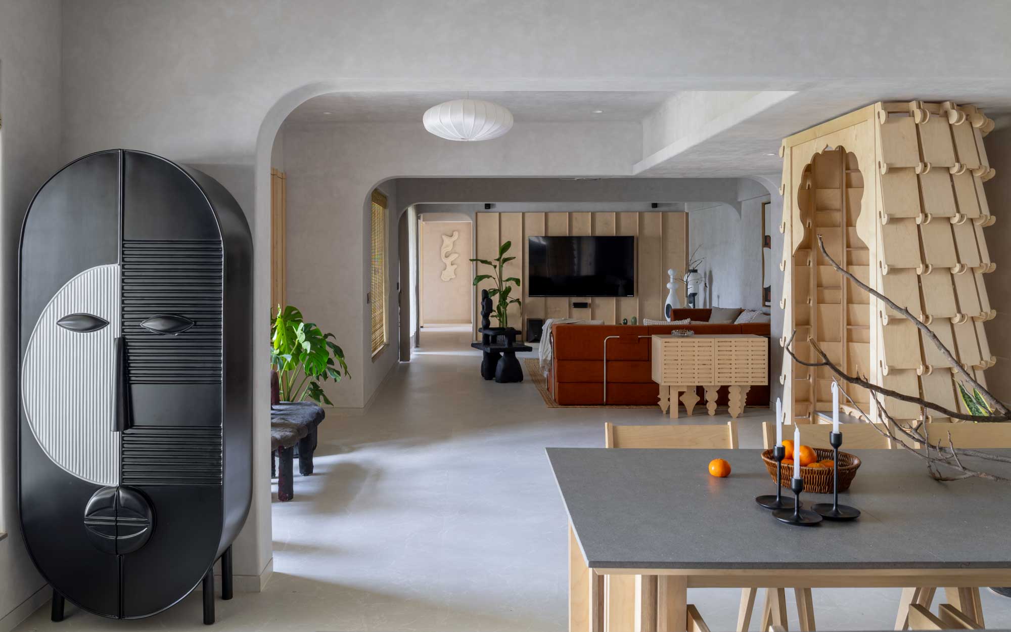 The living area leads to the open-plan kitchen and dining area. The flooring from Simpolo Tiles and Bathware and ceiling work from Gyproc give the space a pared-back look.  The lighting fixtures are from Litomatic. (Image Credits: Viveekajeet Purohit)