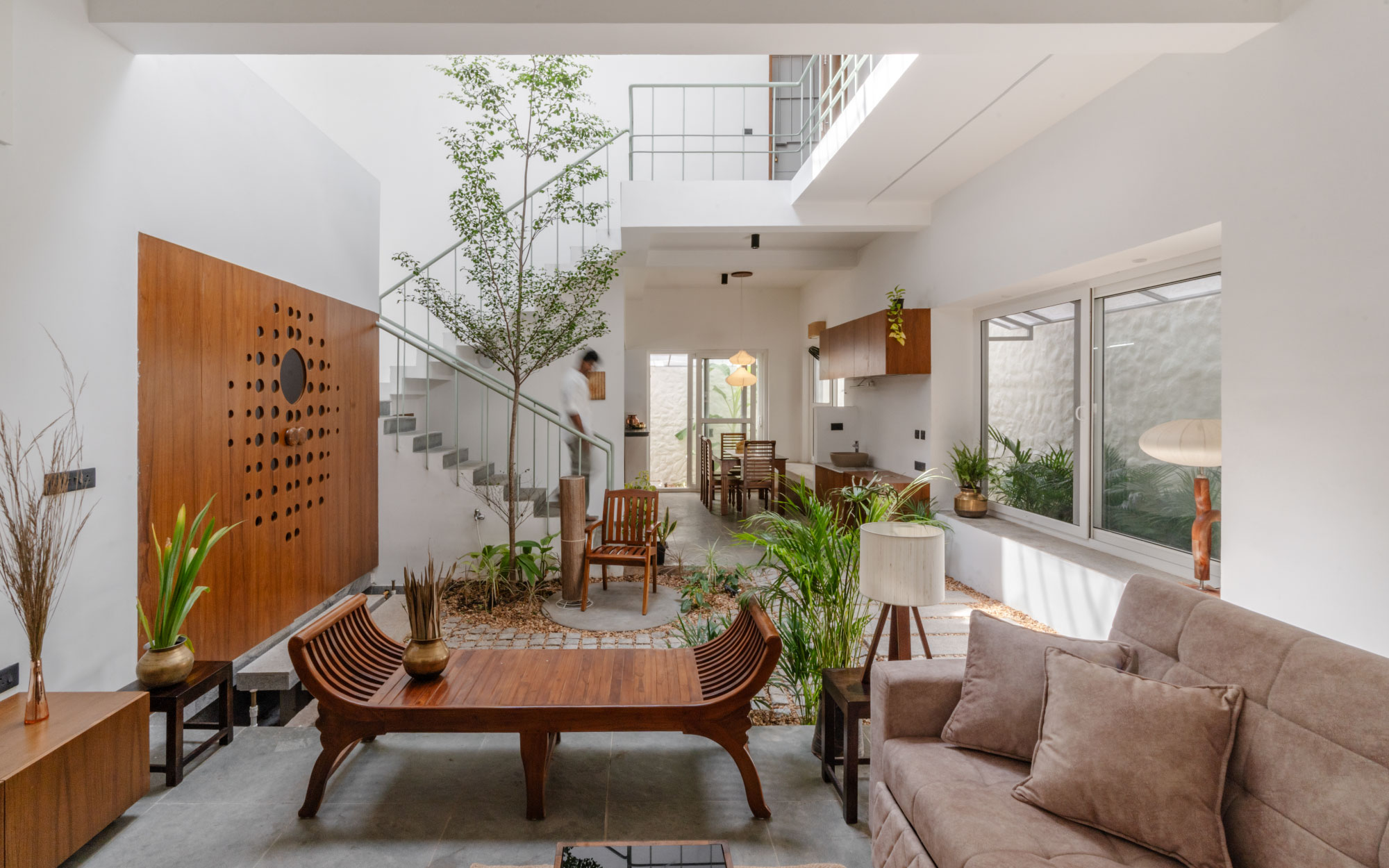 With a biophilic design and ample verdancy, the central garden of this home features furniture from Capital Grand Furniture and floor lamps from Auro Bala Lampshades, Auroville. (Image Credit: Priyanka Rajan)