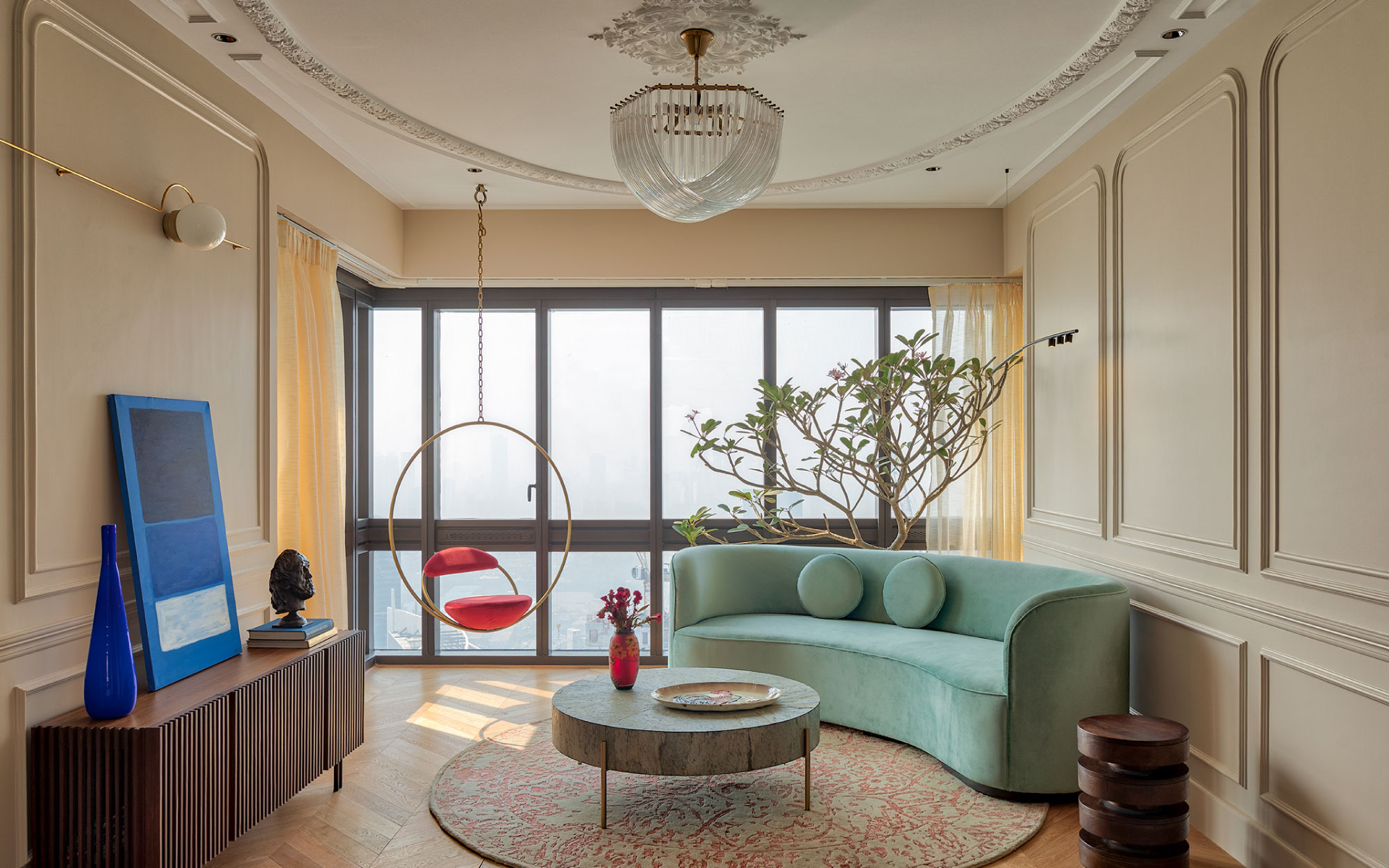 With a bespoke curvilinear couch, coffee table from Pinakin Studio and chandelier from The White Teak Company, the living area perfectly channels a Parisian chic vibe. (Image Credits: Pulkit Sehgal)