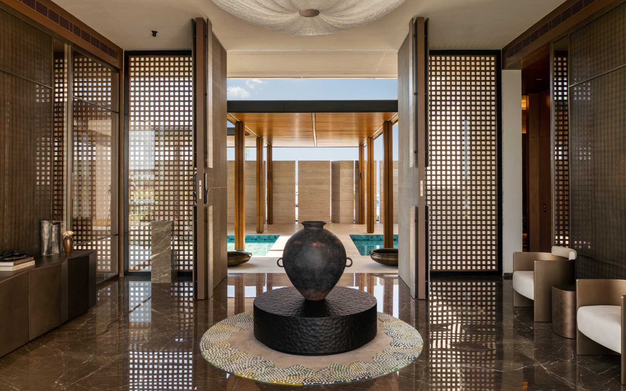 The foyer unfolds as a quiet prelude to the home, a contemplative pause where light, art, and volume gently announce the architecture within. (Image Credits: Suryam Developers)
