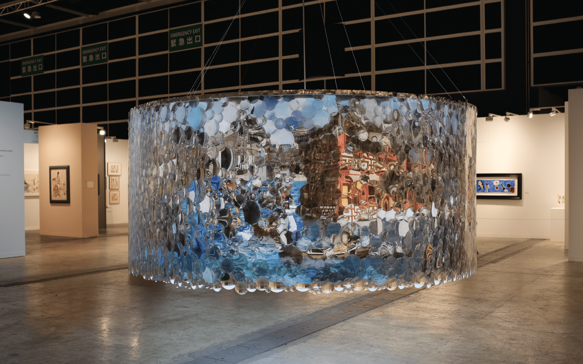 Suzann Victor’s work is a kinetic installation with a rotating photographic mural and Fresnel lenses that traces regional architecture shaped by empire, migration, and layered histories of conflict and memory. (Image Credits: Gajah Gallery)